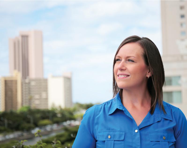 woman smiling and looking left in front of daytime skyline