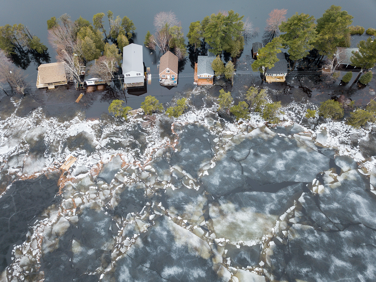 Ice flows and water flood a line of houses in an overhead shot  flooding of the Saint John River in 2019