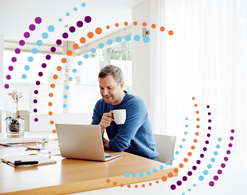 Man drinking coffee at laptop