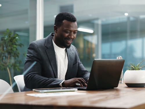 Professional working on a laptop at a conference table.