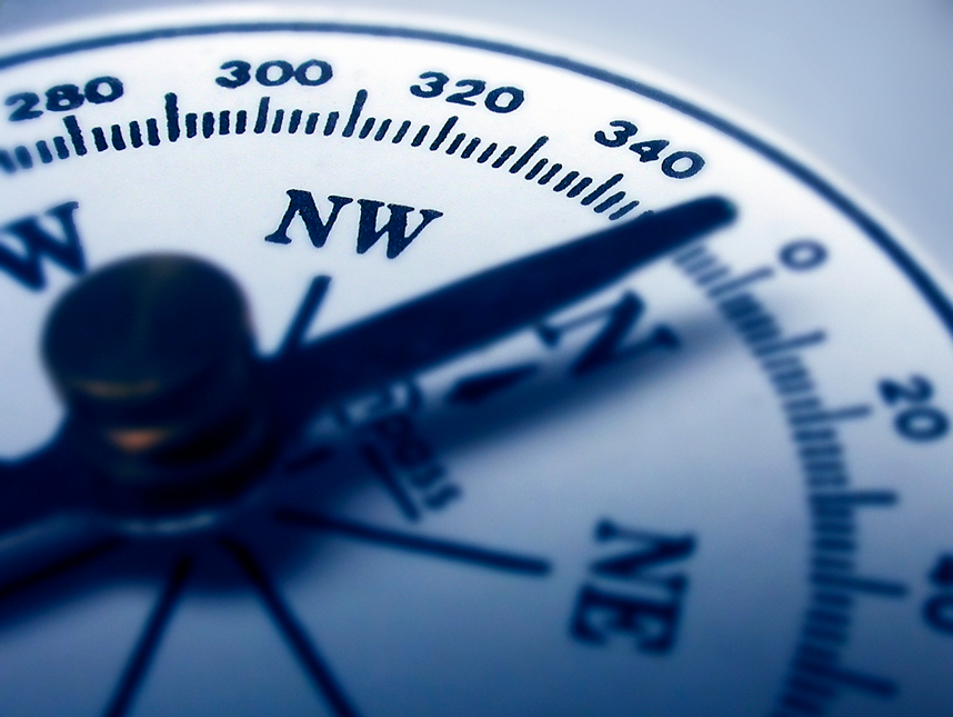 A close up of a compass pointing north