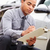 A claims adjuster with a car