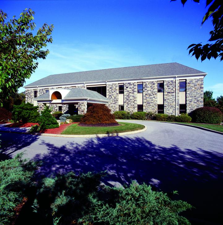 street view of building surrounded by trees and shrubs