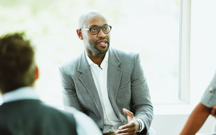 Man in front of window talking to group