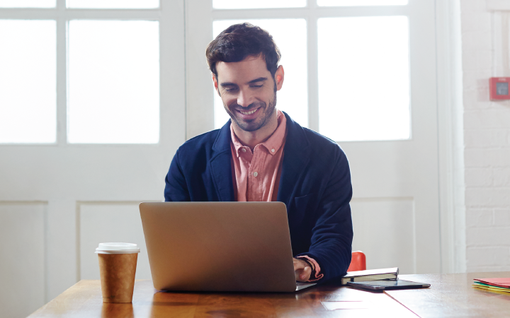 Man smiling in front of computer
