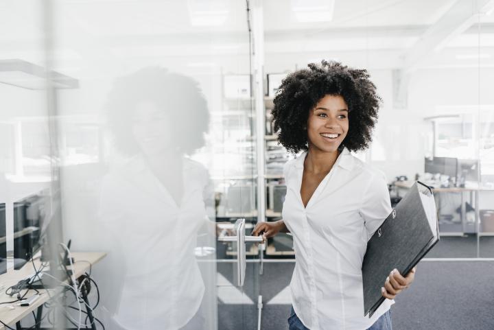 woman smiling walking into door