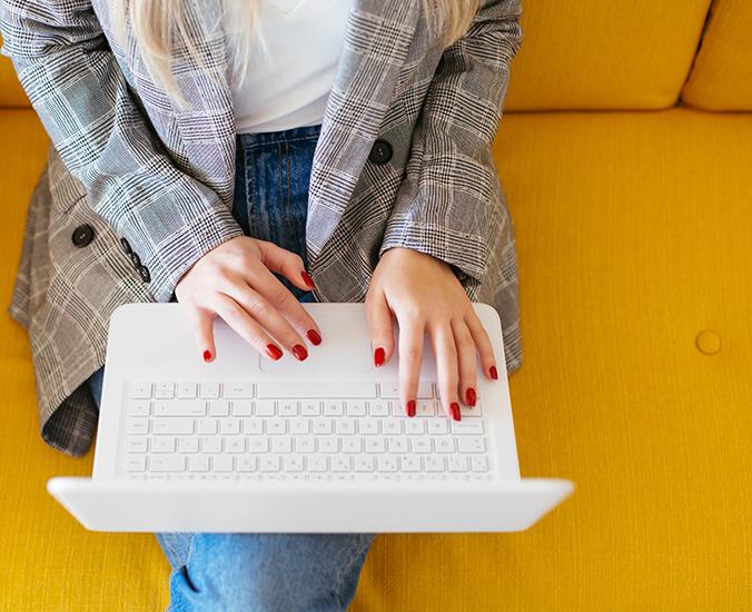 Woman in blazer typing on laptop