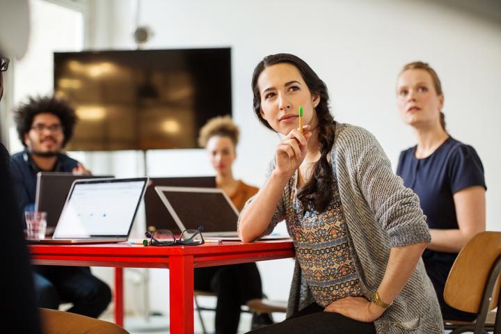 A group of coworkers sit collaborating and learning together.