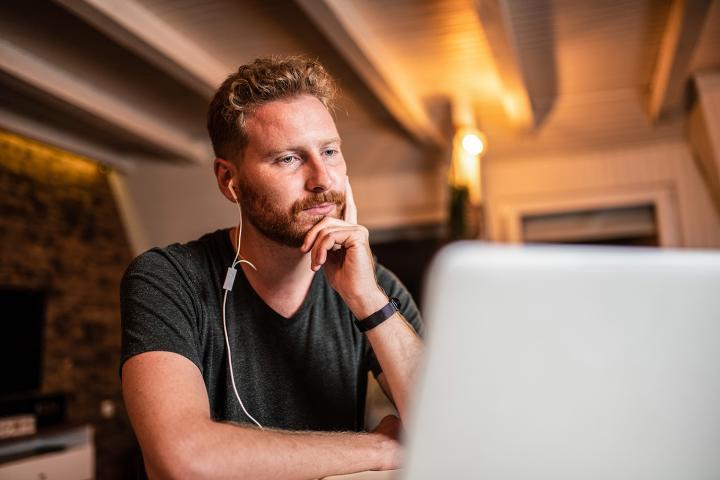 Young bearded man learning on a laptop