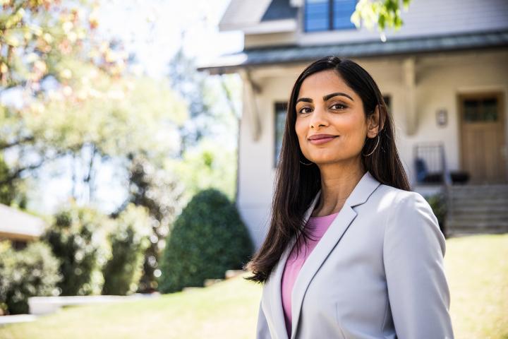 Real Estate Agent standing in front of a house