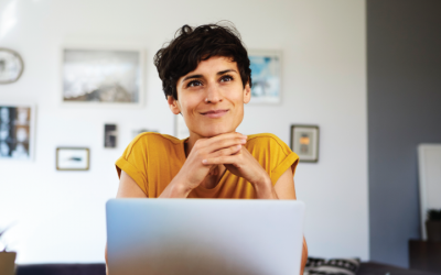 Woman in yellow sitting in front of computer screen