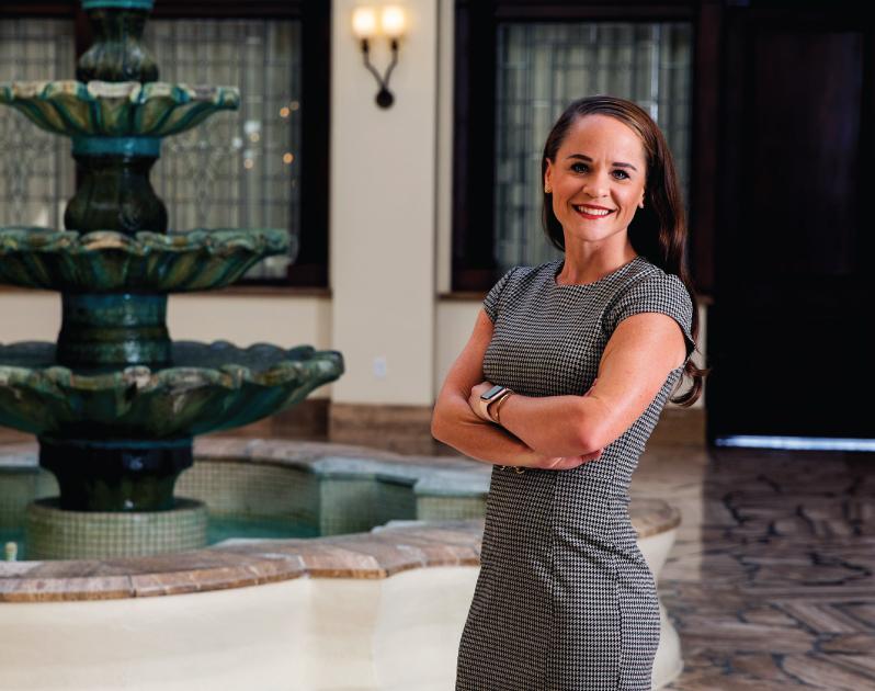 woman standing in front of fountain with arms crossed, smiling