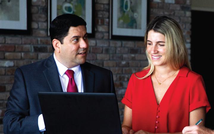 Man and woman talking in front of laptop